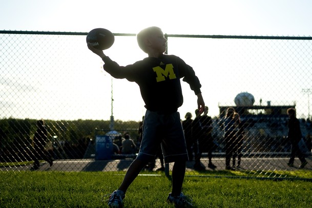 Saline fan Rylan Runske, 7, tosses a football with his dad before the game against Pioneer on Friday. Daniel Brenner I AnnArbor.com